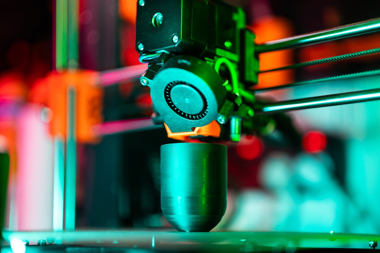 portfolio-04 Close-up of a 3D printer creating a product in neon lighting.