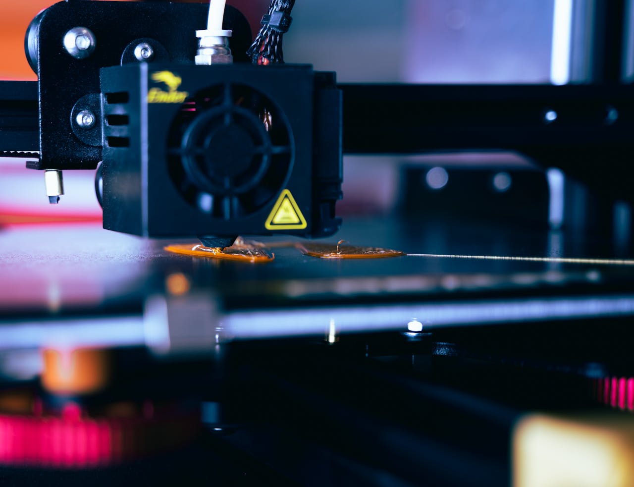 portfolio-08 Detailed view of a 3D printer head during operation, showcasing modern printing technology.